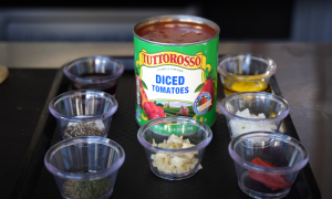 Ingredients for homemade tomato sauce, including garlic, onion, tomato paste, Italian seasoning, and crushed tomatoes