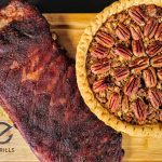 Smoked ribs and pecan pie cooked on a Z Grills cutting board, showcasing the grill's versatility.