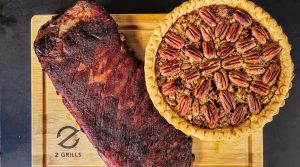 Smoked ribs and pecan pie cooked on a Z Grills cutting board, showcasing the grill's versatility.