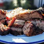 Plated smoked chuck roast cut into chunks and slices on a white dish with a blue rim