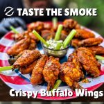 Plate of smoked buffalo wings with celery and blue cheese dip, arranged on a patriotic plate with the text “Taste the Smoke – Crispy Buffalo Wings.”