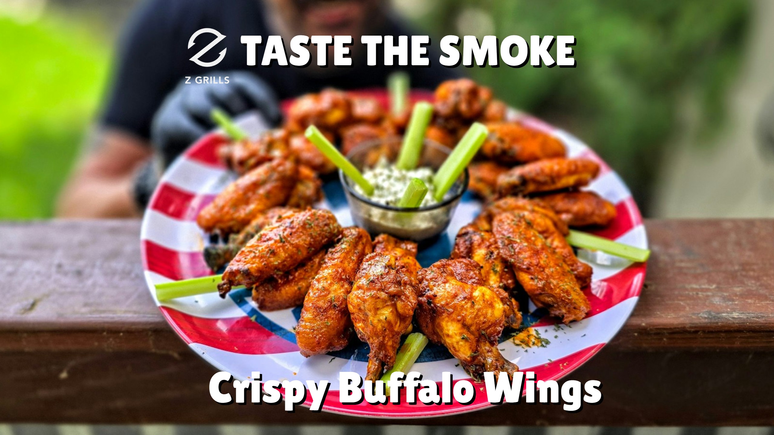 Plate of smoked buffalo wings with celery and blue cheese dip, arranged on a patriotic plate with the text “Taste the Smoke – Crispy Buffalo Wings.”