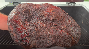 Close-up of smoked brisket with dark bark and glistening surface just pulled off a Z Grills pellet smoker.