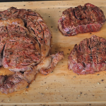 Cooked ribeye and filet mignon steaks resting on a Z Grills cutting board after searing.