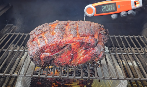 Thermometer reading 200°F inserted into smoked pork butt on a pellet grill.